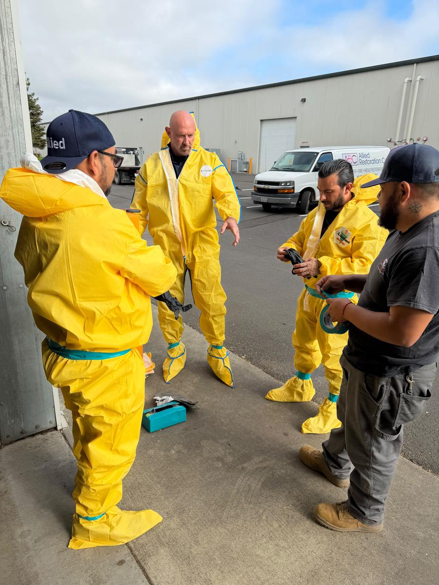 Allied technicians donning hazmat suits for biohazard response