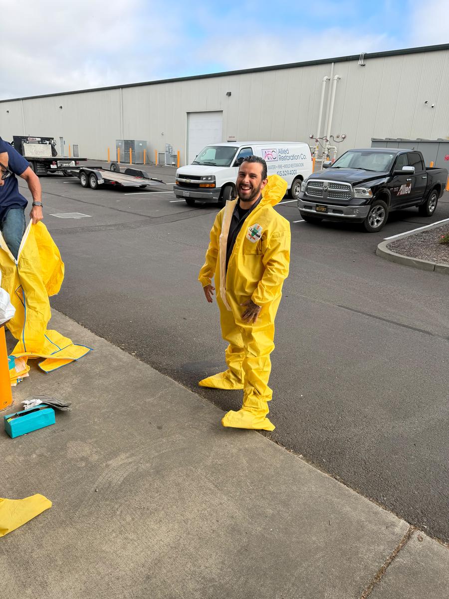 Allied technician in hazmat suit with response vehicle
