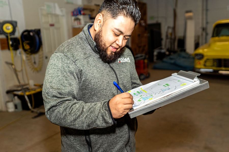 Allied Restoration technician documenting damage for insurance claim